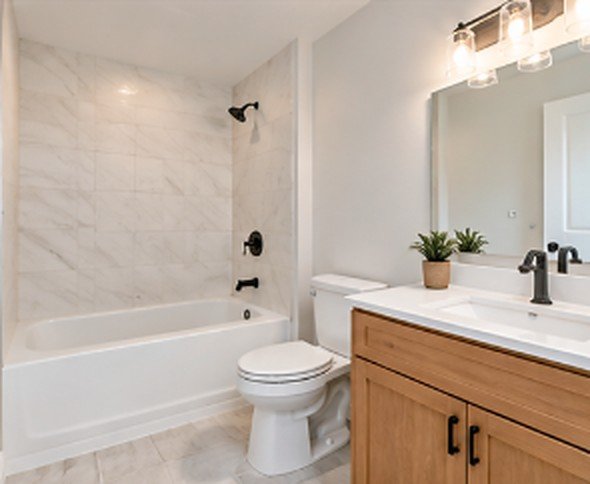 Finished bathroom with smooth walls, tub surround and vanity