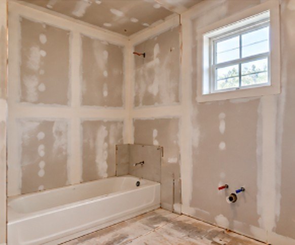 Bathroom with hung and taped drywall around a new tub